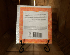 Image shows the back of the book/card, Animal Poems. The cover is white with a patterned orange and yellow boarder. It is displayed on a book stand.
