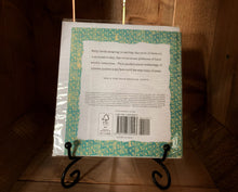 Load image into Gallery viewer, Image of the back of the book/card Nature Poems. The cover shows a white background with a green patterned border, with the blurb in the center written in black text. It is displayed on a book stand. 