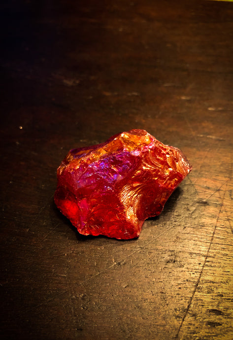 Image of a red Fire Rock, otherwise known as quartz stones plated in different metals to provide a rainbow sheen