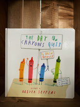 Load image into Gallery viewer, Image of the front cover of The Day the Crayons Quit. The cover has a plain white background, and features an illustration of 4 anthropomorphized crayons, orange, red, blue, and green, holding protest signs. The title is written as if with crayons on a sign, which is being held by the red crayon.