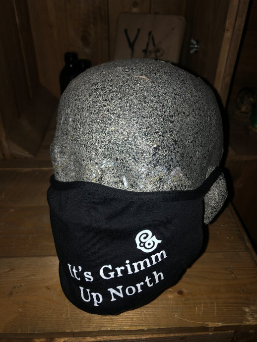Image shows black jersey face mask printed with white text slogan saying 'It's Grimm Up North' with the Grimm & Co 'G' monogram, mask is shown displayed on a mannequin head.