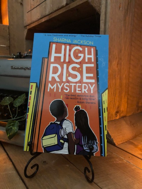 Image of the paperback book High Rise Mystery written by Sharna Jackson shown in a book stand