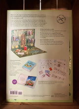 Load image into Gallery viewer, Image of the back of the box for My Fairy Library. The back has a pale green background, and shows images of the library when fully set up, a close up of the miniature books open and closed, and an image of all the books included. Information about the contents of the box is written around the images in black text.