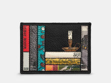 Load image into Gallery viewer, Image shows the front of the black Yoshi leather slim card holder featuring appliqued book spines of titles written by Charles Dickens. Titles include A Christmas Carol, The Pickwick Papers, Oliver Twist and Great Expectations. An appliqued candle in a candle holder sits on top of a stack of books.