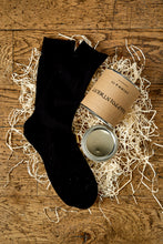Load image into Gallery viewer, Image of an example black sock next a tin of disappointment laying on its side in a nest of wood wool with the lid removed.