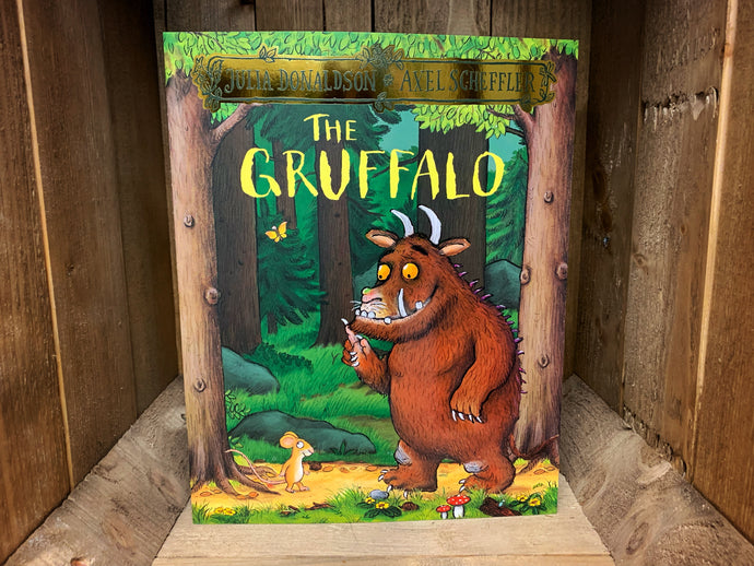 Image shows the front cover of the book The Gruffalo. The cover has a full illustration of the Gruffalo and the Mouse standing in the woods, in shades of green and brown. 