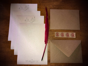 Image shows the opened Letter Writing Supplies containing 8 sheets of cream textured paper printed with a design of potion bottles and wording, a red biro quill, 4 kraft envelops embossed with the Grimm & Co 'G' monogram and set of 4 red monogram stickers