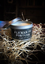 Load image into Gallery viewer, Image of a candle in a tin called Flicker of Fortune, lid is removed to reveal candle wax and wick inside