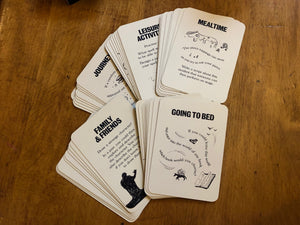 Image shows the Stems of a Story game cards in small piles of their categories: mealtime, going to bed, family& friends, journeys, and leisure activities.