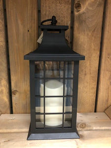 Image showing a black coloured Bright Ideas lantern with a square lattice pattern on the windows with a battery operated candle inside and a handle on the top.