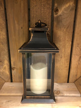 Load image into Gallery viewer, Image showing a bronze coloured Bright Ideas lantern with plain windows with a battery operated candle inside and a handle on the top.