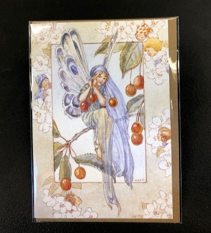 Image shows the Fairy Land greetings card with a fairy sat on a cherry tree branch holding cherries with five hidden fairies around the border sit amongst white cherry blossom flowers. Illustration is in full-colour and comes with a kraft envelope.