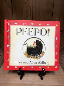 Image of the front cover of Peepo! Board book with cut out circle to peep through to page one. Cover image features a baby in a black pram.