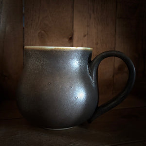 Image of a Travel Cauldron, more commonly known as mugs in the mortal realm, ceramic and dyed a rich copper to black colour, each one is unique and handmade. The regular sized mug has the Grimm & Co 'G' monogram stamped into the base of the handle. 