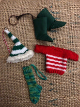 Load image into Gallery viewer, Image shows the variety of knitted elf items that will be packed randomly inside the Gift Box to Mull Over. These could include a knitted elf hat, a knitted jumper, knitted stocking or some felt boots