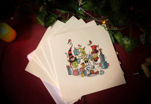 Load image into Gallery viewer, Image of a pack of 5 greetings cards showing a cartoon illustration of three shop elves amid present wrapping and snacks drawn by Chris Mould. Display shows the cards laid out on a table with candles and ivy.