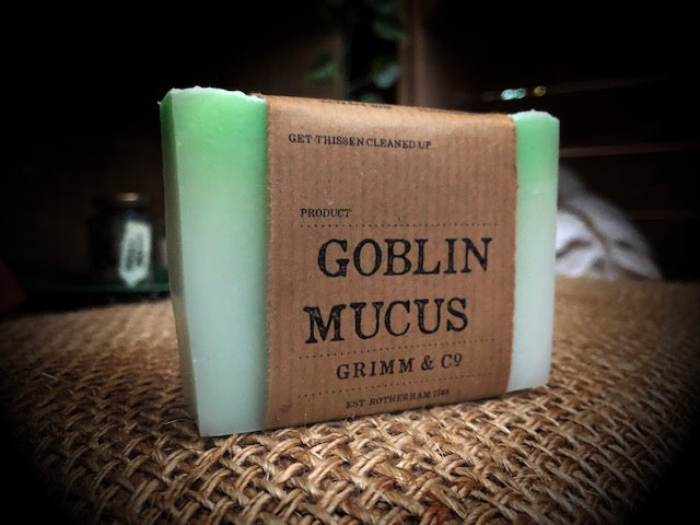 Image of Goblin Mucus bar, otherwise known as an apple and elderflower scented white and green soap slice. Soap shown with kraft paper label.