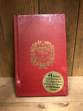 Load image into Gallery viewer, Image shows the front cover of the hardback book A Christmas Carol with a red clothbound cover and gold foil lettering.  A gold sticker on the cellophane sleeve says &#39;A Faithful reproduction of the original first edition of Dicken&#39;s A Christmas Carol&#39;.