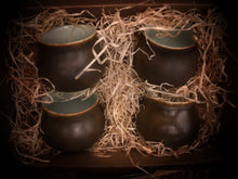 Load image into Gallery viewer, Image of a set of four Mini Travel Cauldron espresso cups without handles nestled in a box with wood wool packaging.