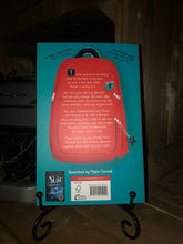 Load image into Gallery viewer, Image of the back cover of the paperback book The Boy at the Back of the Class written by Onjali Q Raúf and illustrated by Pippa Curnick. Displayed on a book stand.