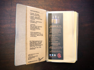 Image of a journal opened at the front, showing the clear storage sleeve containing a bookmark, and the part of the kraft label on the inner cover, which lists the faux ingredients and side effects.