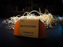 Load image into Gallery viewer, Image of a slice of Motivation potion, otherwise known as ginger scented solid shampoo bar wrapped in a kraft paper label.
