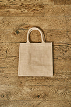 Load image into Gallery viewer, Image of the back of a jute tote bag