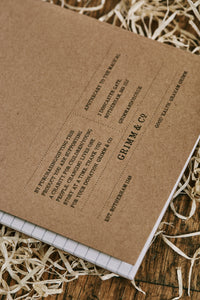 Close up detail of the back cover of the Songs, Poems, Curses kraft notebook with lined pages.