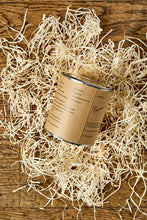 Load image into Gallery viewer, Image of the back of a tin of Disappointment with a kraft label showing the faux ingredients and side effects. Tin is sat in a nest of wood wool. 