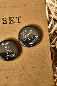 Image showing a black button badge with the slogan 'It's Grimm Up North' printed in white text.