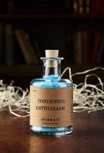 Image of Condensed Enthusiasm, otherwise known as scented, baby blue bath salts in a glass bottle with cork 