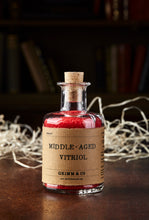 Load image into Gallery viewer, Image shows a bottle of Middle Aged Vitriol, otherwise known as red, scented bath salts in a glass bottle with cork lid and a kraft paper label
