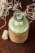 Load image into Gallery viewer, Close up image of Pot Luck with cork out of the bottle, otherwise known as scented, pale green bath salts in a glass bottle.