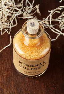 Top view image of Eternal Ugliness otherwise known as scented, orange coloured bath salts in a glass bottle with cork