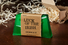 Load image into Gallery viewer, Luck of the Irish, otherwise known as a green, mango scented soap slice. Soap has white coloured soap strands suspended inside the green slice, and it is wrapped with a kraft label.