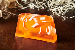 Image of No More Newt, an orange potion also known as an orange scented soap slice shown without the kraft paper label. Soap has white soap strips suspended inside the orange slice.