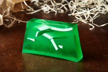 Load image into Gallery viewer, Luck of the Irish, otherwise known as a green, mango scented soap slice. Soap has white coloured soap strands suspended inside the green slice, and it is shown without the kraft label.