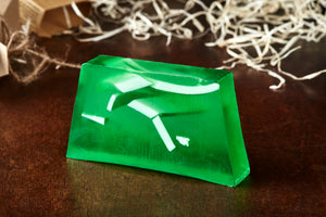 Luck of the Irish, otherwise known as a green, mango scented soap slice. Soap has white coloured soap strands suspended inside the green slice, and it is shown without the kraft label.