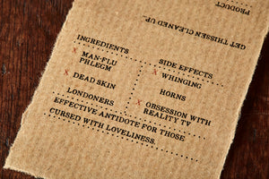 Image shows kraft paper label for Human Phlegm bar, a melon scented soap slice. Label lists the faux ingredients and side effects.