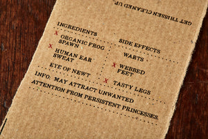 Image shows kraft paper label for Frog Spawn bar, a kiwi scented soap slice. Label lists the faux ingredients and side effects.