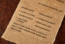 Load image into Gallery viewer, Close up image of the kraft label with the faux side effects and ingredients for Luck of the Irish