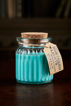 Load image into Gallery viewer, Image shows a Northern Lights Candle called Siren&#39;s Light. The candle is turquoise soy wax in a small glass pot with cork lid and is apple and cinnamon scented.