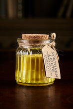 Load image into Gallery viewer, Image shows a Northern Lights Candle called Summer Solstice. The candle is yellow soy wax in a small glass pot with cork lid and is honeysuckle scented.