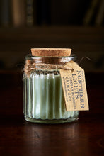 Load image into Gallery viewer, Image shows a Northern Lights Candle called Indian Summer. The candle is pale green soy wax in a small glass pot with cork lid and is cucumber scented.