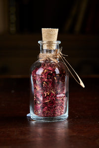 Image of Happily Ever After, a small decorative glass bottle with cork containing dried rose petals and tied with twine and a kraft paper label