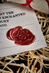 Close up detail image of the red wax seal on the certificate of authenticity, stamped with the Grimm & Co 'G' monogram