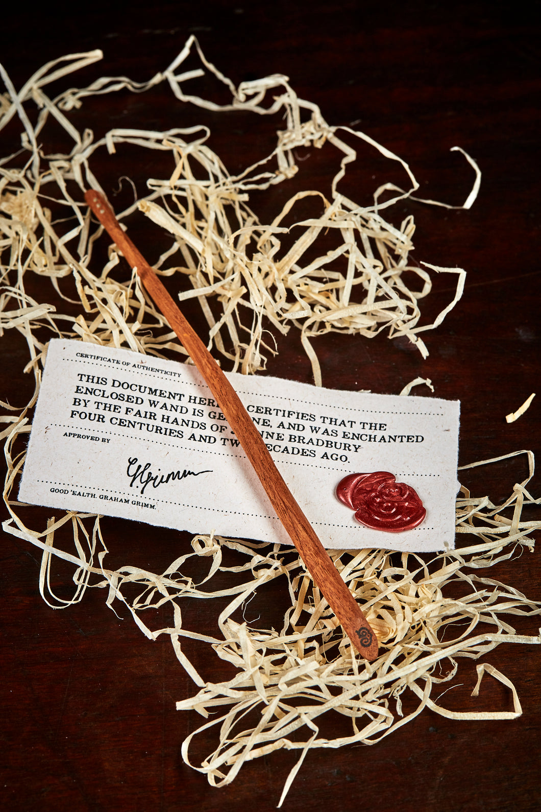 Image of a large handmade advanced wand, wooden decorative wand stamped with a black Grimm & Co 'G' monogram at the base of the handle. Wand has three dots of sterling silver at the tip, wand wood is a rich brown colour and comes with a wax sealed certificate of authenticity