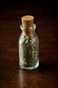 Mini glass bottle with cork containing Leprechaun Gold, otherwise known as iron pyrite or fool's gold pieces