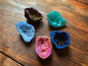 An image showing a collection of assorted colours of quartz geodes for the vacated genie geodes. These are shown inside facing up to display all the sparkling crystals inside