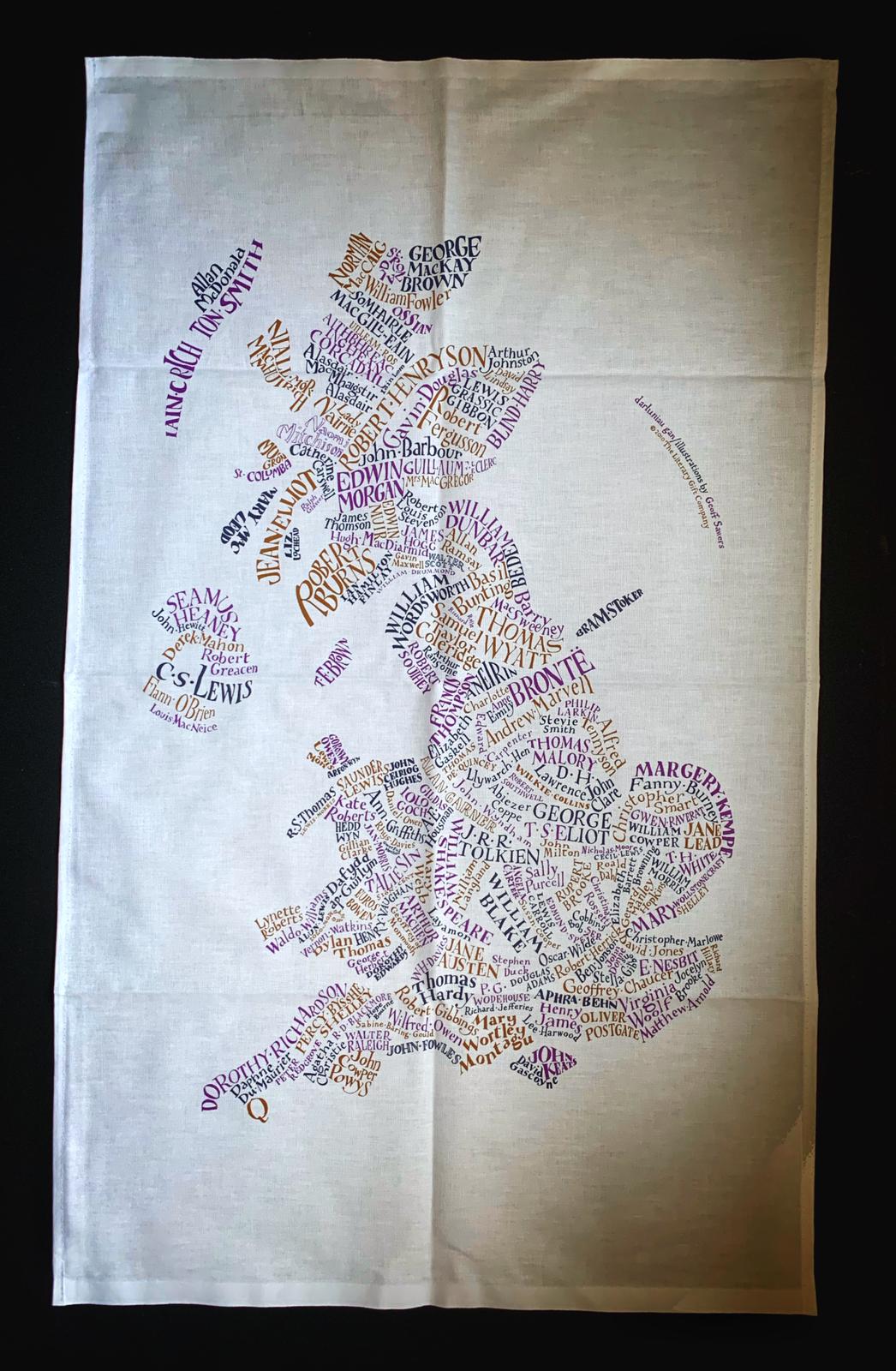 Image shows the Giant Handkerchief unfolded to display design printed in purple, orange and slate grey on white cotton tea towel.  Design shows a literary map of Britain with names of famous authors shaped in and around the areas where they lived.